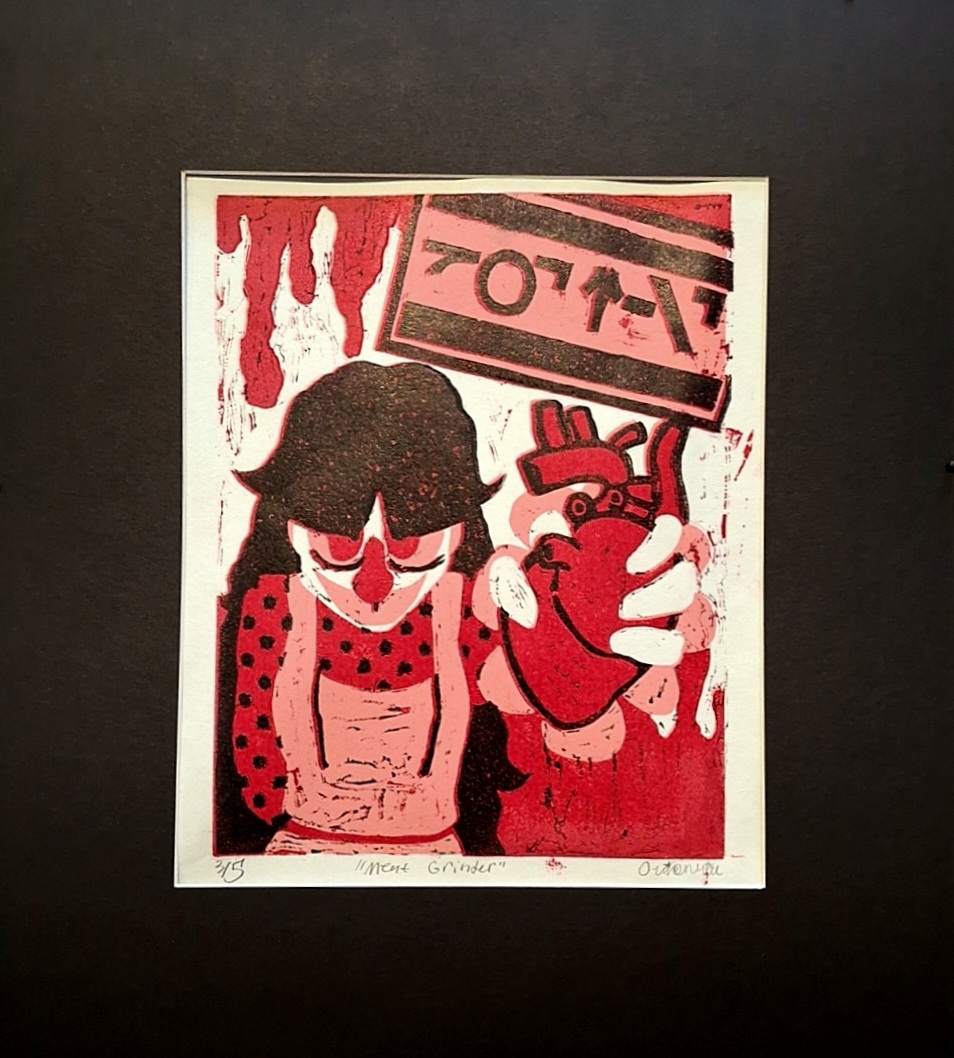 
A photograph of a print surrounded by matboard. It has pink, red, and black on white paper. It depicts a woman hunched over- cut off at the waist- with her arm extended to the viewer. She is holding a human heart in a tight grip. There is an abstract sign behind her in another language reading 'GOT MEAT'. The background looks as if there is blood spilling on the top and bottom.